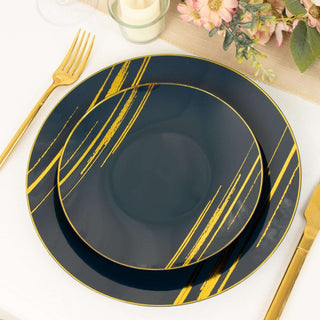 Navy blue plates with gold stripes on a table setting