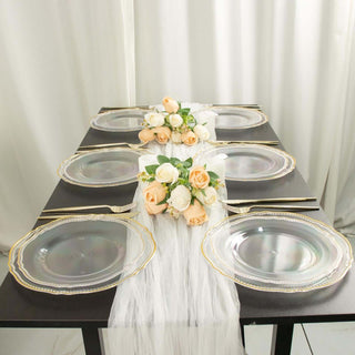 Elegant table setting with clear plates and floral centerpiece.