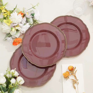 Set of three elegant burgundy plates with decorative edges.