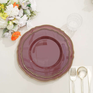 Elegant burgundy plate with gold accents on a neutral table setting.