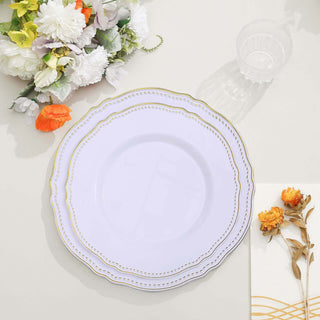 Elegant white plate with gold trim on a table with floral arrangement and napkin.