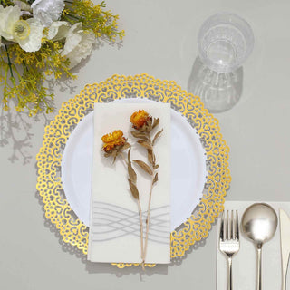 Elegant gold lace plate setting with flowers and cutlery on a neutral table.