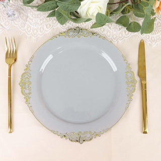 Elegant gray plate with gold ornate trim, set with gold fork and knife.
