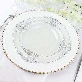 Elegant white plate with silver detailing and gold beaded rim on a table setting.