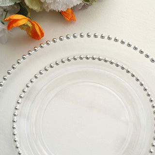 Clear glass plates with beaded edges, elegantly displayed with flowers.