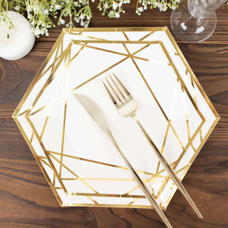 Gold geometric hexagon plate with fork and knife on a wooden table.