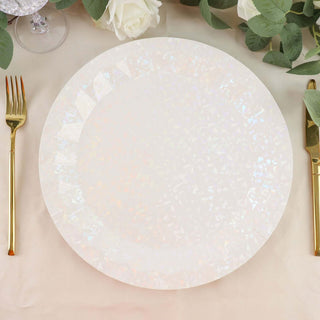 Iridescent plastic plate on a table with gold utensils and greenery.