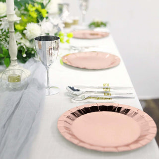 Elegant pink and silver table setting with plates, cutlery, and decor.
