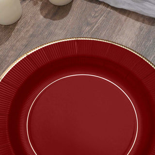 Red plate with gold rim on wooden surface.