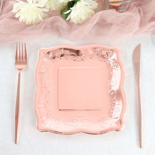 Rose gold decorative plate with fork and knife on a table setting.