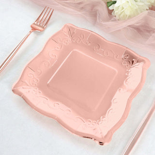 Pink decorative plate with ornate edges on a soft tablecloth.