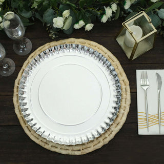 Elegant silver plate on a woven charger with cutlery and decor elements.