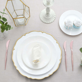 Elegant dining table setting with white plates, pink cutlery, and decorative cupcakes.