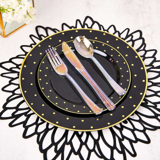 Elegant black and gold dinnerware set on a decorative black placemat.
