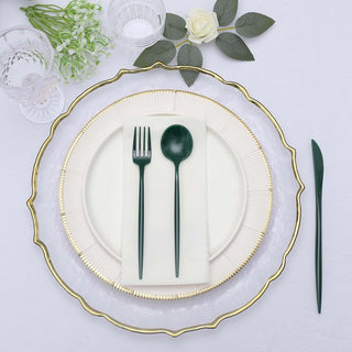 Elegant green utensils on a decorative plate setting with floral accents.