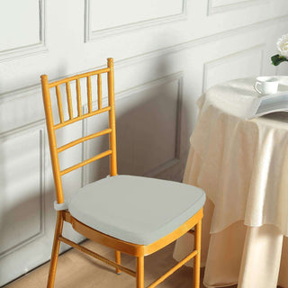 Yellow wooden chair with a gray cushion beside a table.