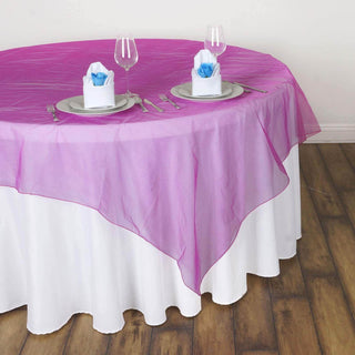 Pink sheer table overlay on a white tablecloth with elegant table settings.