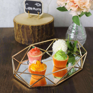 Colorful cupcakes displayed on a mirrored tray with decorative flowers and a wooden stand.