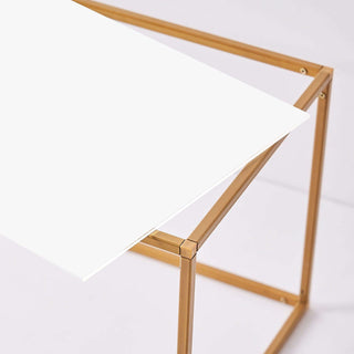 Modern white desk with gold frame, showcasing sleek design.
