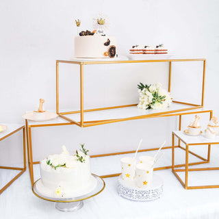 Elegant dessert display with cakes and treats on gold metal stands.