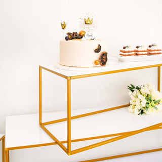 Elegant cake on a modern gold and white display table with decorations.
