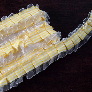 Yellow gingham ribbon with ruffled edges on a dark background.