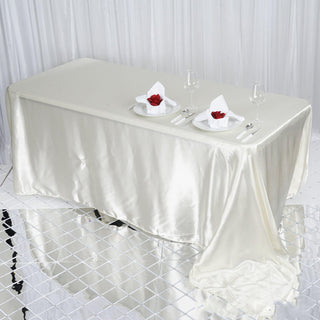 Create Unforgettable Moments with the Ivory Satin Seamless Rectangular Tablecloth Create Unforgettable Moments with the Ivory Satin Seamless Rectangular Tablecloth