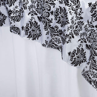 Black and white damask fabric draping elegantly against a plain background.
