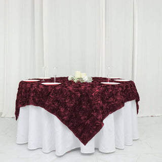 Elevate Your Tablescape with the Burgundy 3D Rosette Satin Square Table Overlay Elevate Your Tablescape with the Burgundy 3D Rosette Satin Square Table Overlay