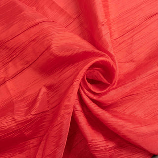 Textured red fabric in a swirling pattern.