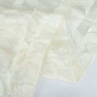 Textured ivory fabric with layered leaf motifs.