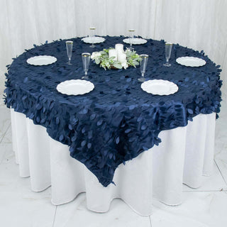 Navy blue leaf-patterned tablecloth on round table with plates and candles