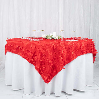 Red tablecloth with petal design draped over a round table.