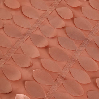 Coral fabric with leaf-shaped embellishments in a textured design.