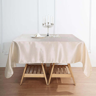 Elegant cream tablecloth draped over a wooden table with candles and decor.