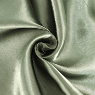 Smooth olive green satin fabric swirl close-up.