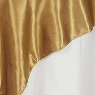 Gold satin fabric draped elegantly, showcasing its smooth texture and rich color.