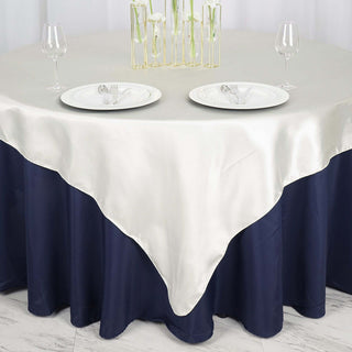 Elegant two-tone tablecloth draping over a round table set for dining.