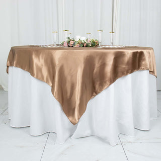 Elegant brown satin tablecloth draped over a round white table.