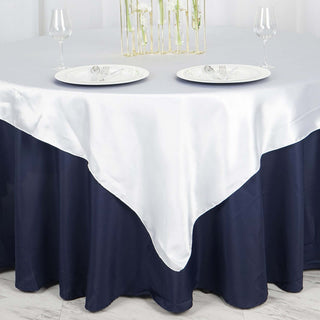 Elegant navy and white tablecloth draped over a round table with plates and glasses.
