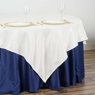 White and navy tablecloth with plates and glasses on a dining table.