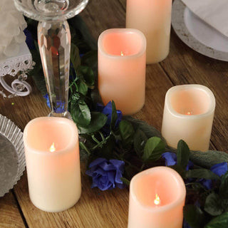Realistic LED candles on a wooden table with decorative flowers.