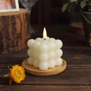Spherical white candle on a wooden plate with a flower