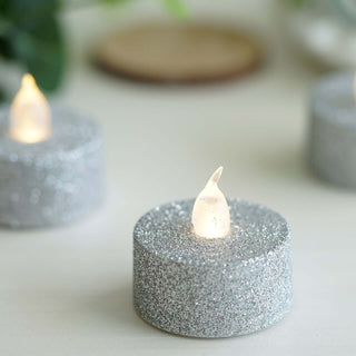 Glittering silver LED candles with a warm glow.