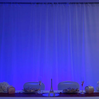Elegant dining setup with Eiffel Tower centerpiece and soft blue lighting.