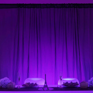 Elegant purple-themed dining setup with champagne glasses and decorative elements.