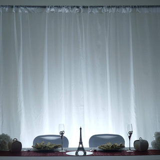 Elegant dining setup with Eiffel Tower centerpiece and white drapes.