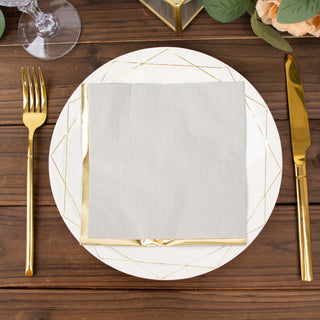 Elegant gold-accented dinnerware set with a folded napkin on a wooden table.