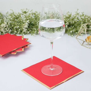 Clear glass of water on red coasters with greenery in the background.