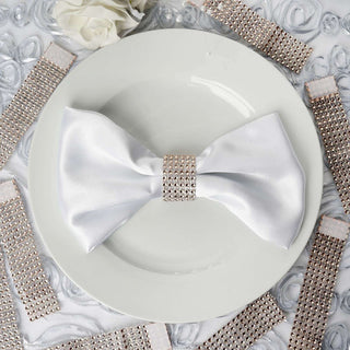 Elegant white satin bow with rhinestone accents on a decorative plate.